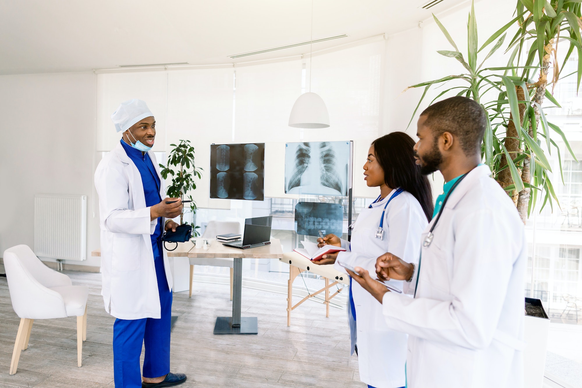 profession, people, surgery, radiology and medicine concept - group of doctors discussing x-rays of