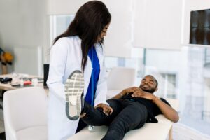 African woman doctor orthopedist examining patient in clinic. Close-up of female physiotherapist