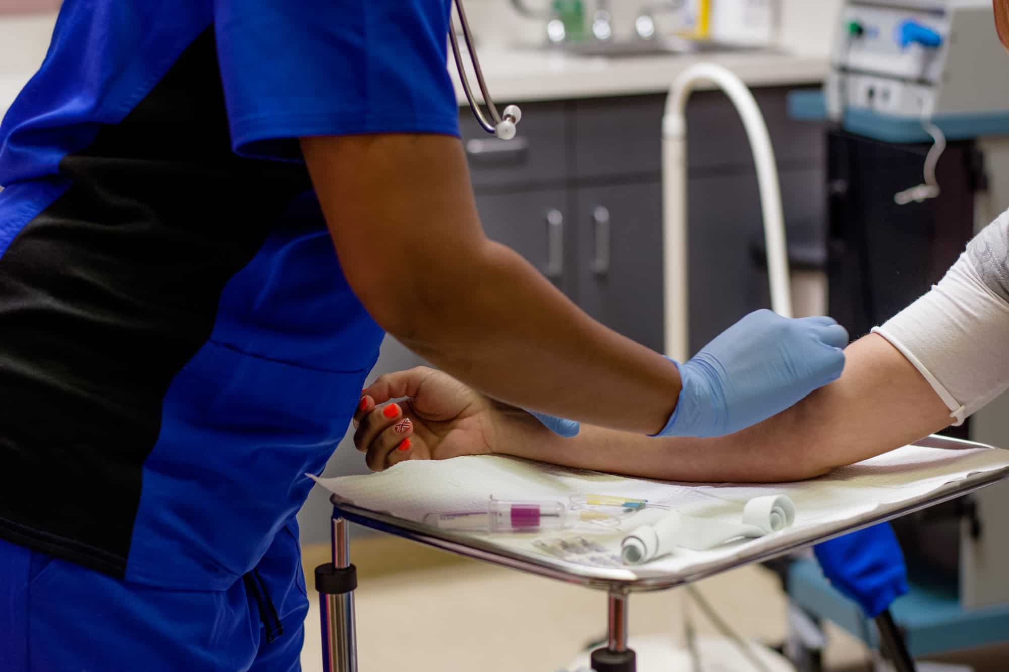 Healthcare’s worker cleaning a woman’s arm with an alcohol pad before she draws her blood