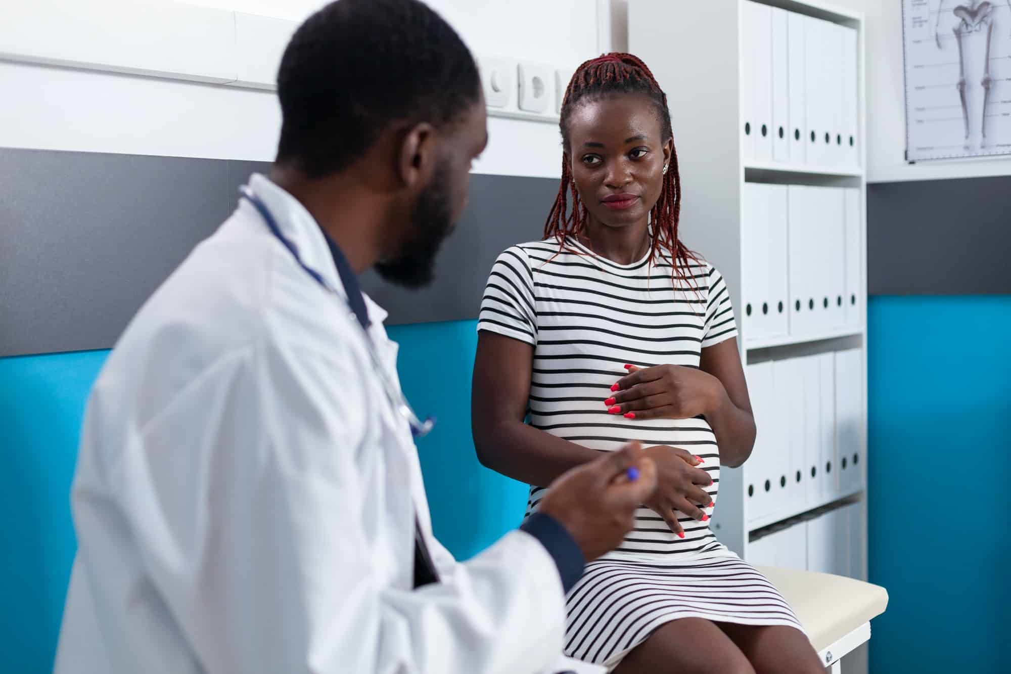 Physician giving medical advice to adult with pregnancy